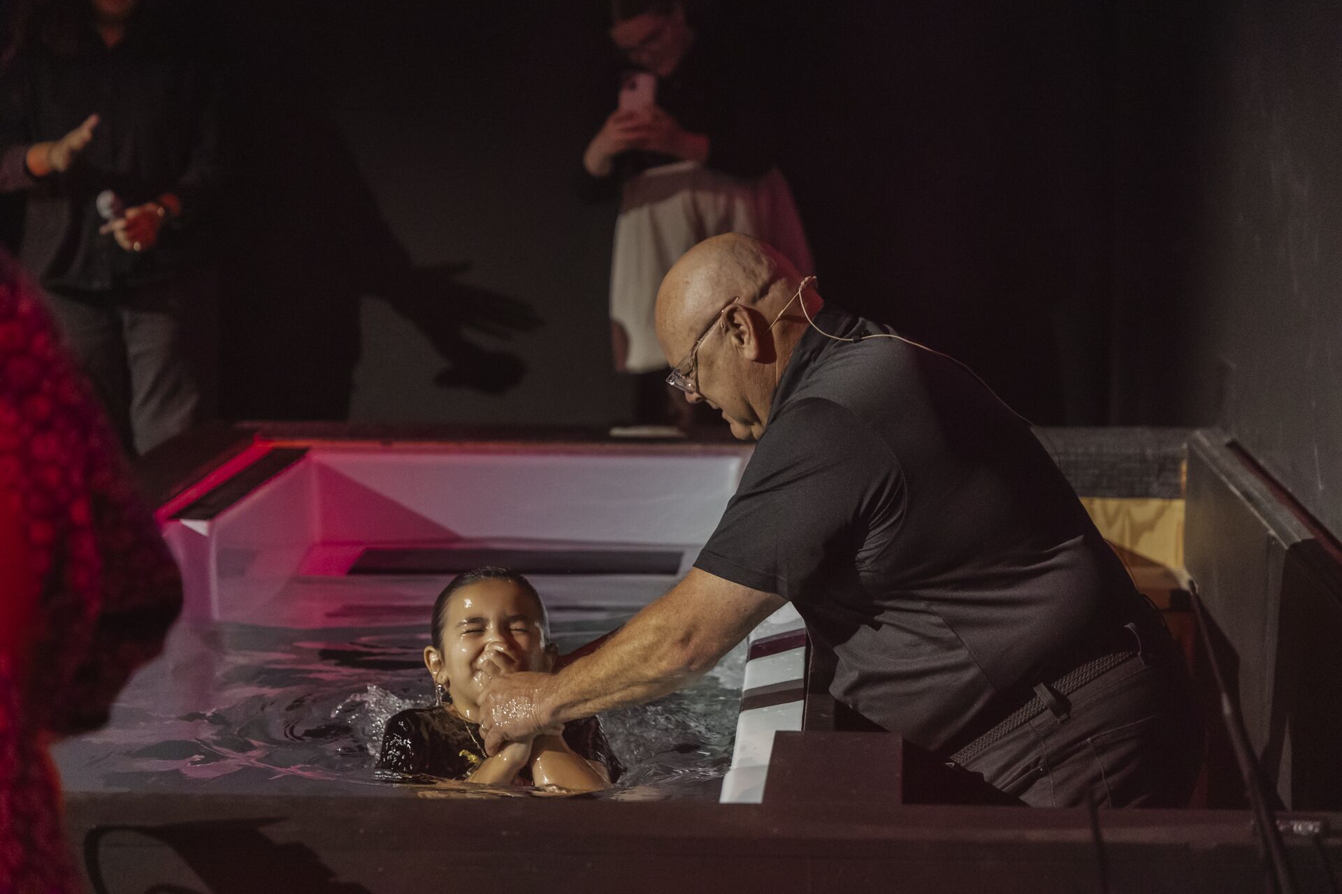 A pastor baptizing a young woman in the baptistry at Pathway Church