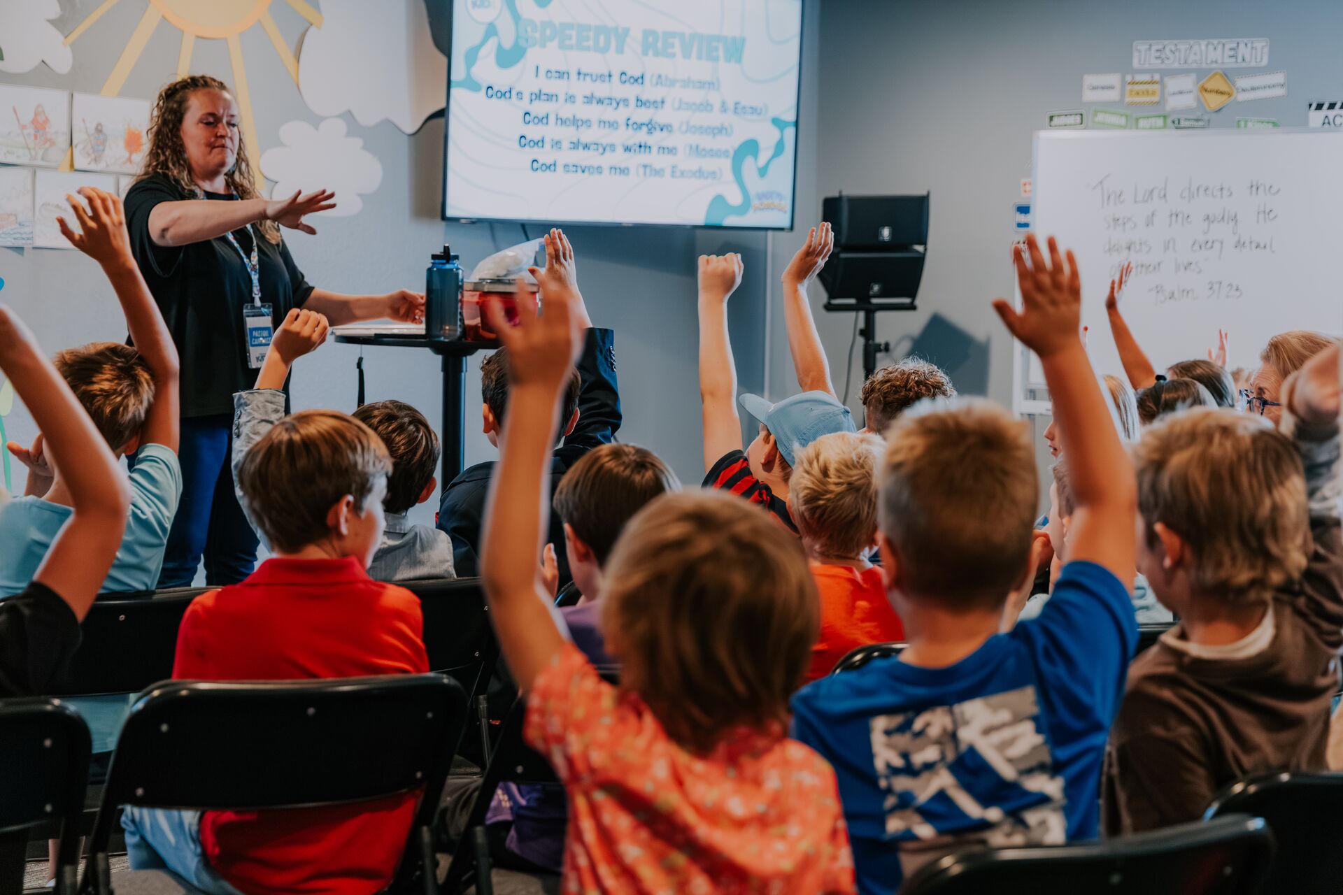 Kids raising their hands during a Pathway Kids lesson
