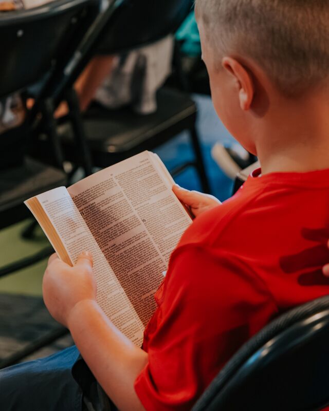 A boy following along in his Bible at Pathway Kids